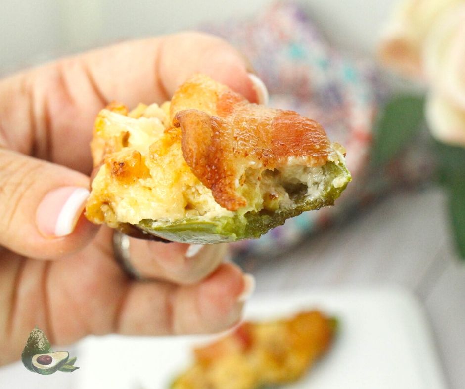 womans hand holding jalapeno popper with bite missing