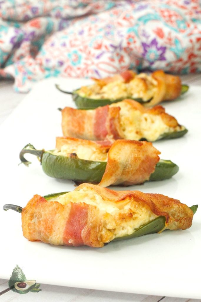 four mexican street corn jalapeno poppers on a white tray with colorful napkin 