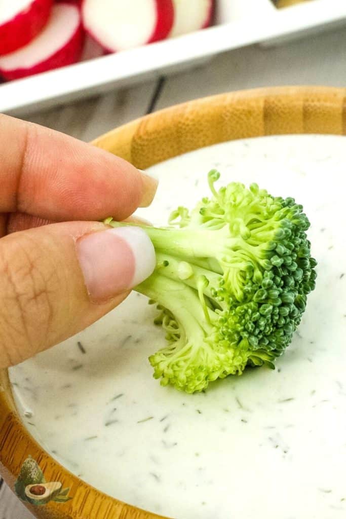 close up broccoli dipped in keto ranch dressing