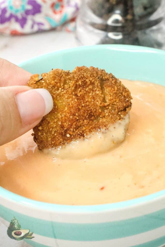 close up keto fried pickle dipping into pink sauce
