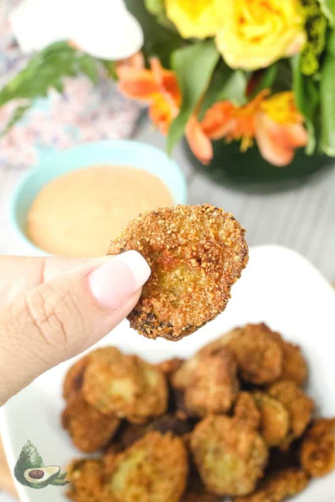 womans hand holding low carb fried pickle