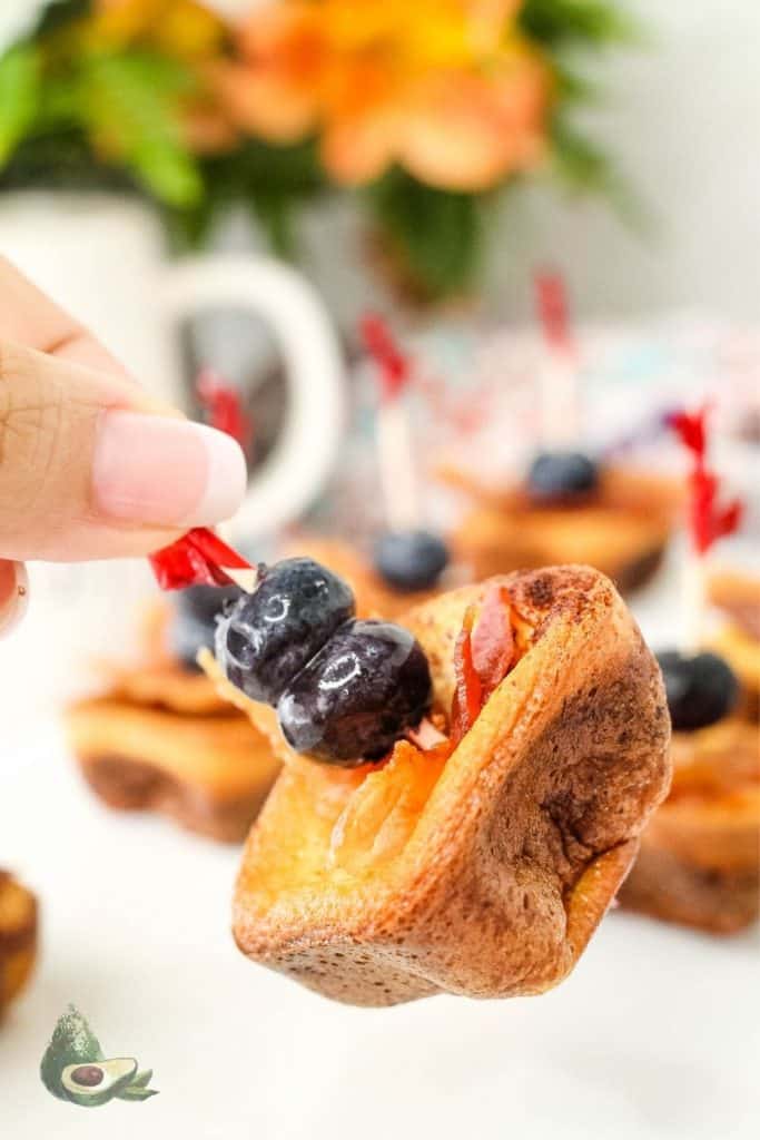 womand hand holding a keto french toast bite on toothpick