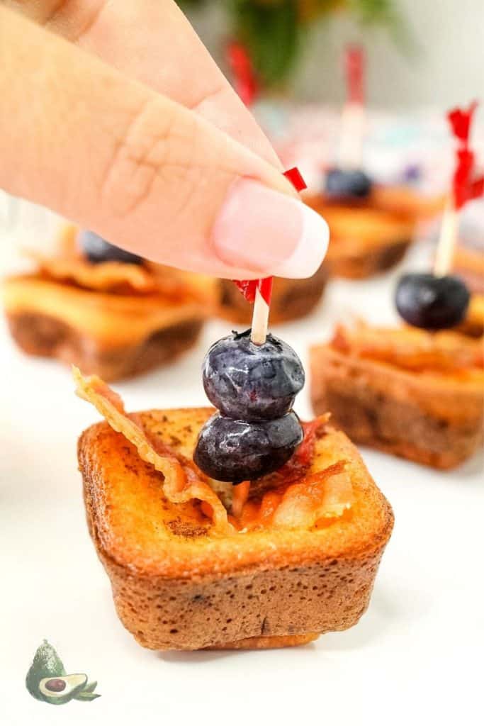 womand hand grabbing keto french toast bite with toothpick 